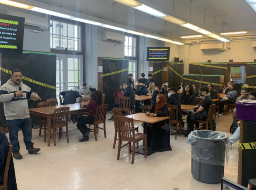Mr. Nelson gives a presentation in the library as the bookshelves are blocked with caution tape. Photo by Alex Hajjar.